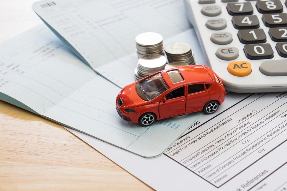 Red Toy Car On Top Of Insurance Papers