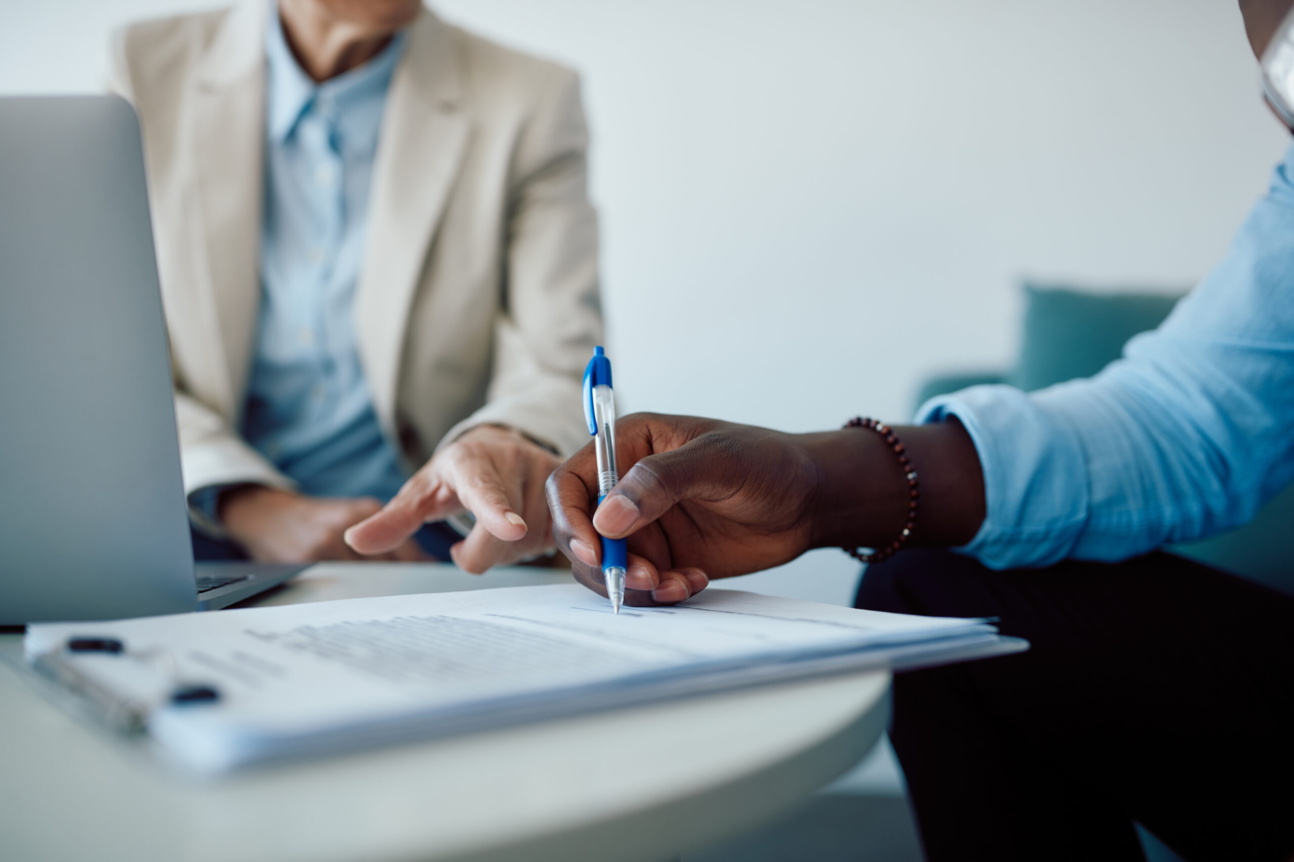 Man signing insurance contract paperwork in an office setting