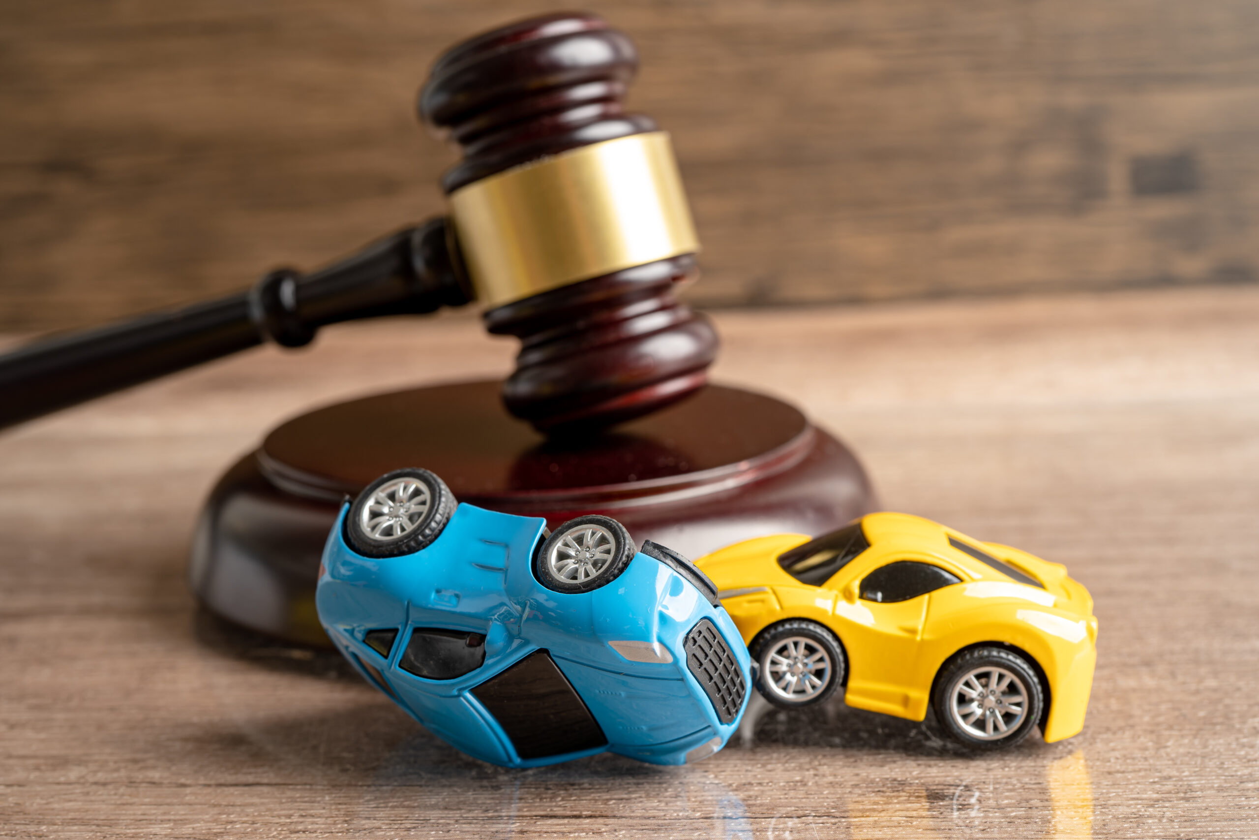 Hammer gavel judge with car vehicle accident, insurance coverage claim lawsuit court case.