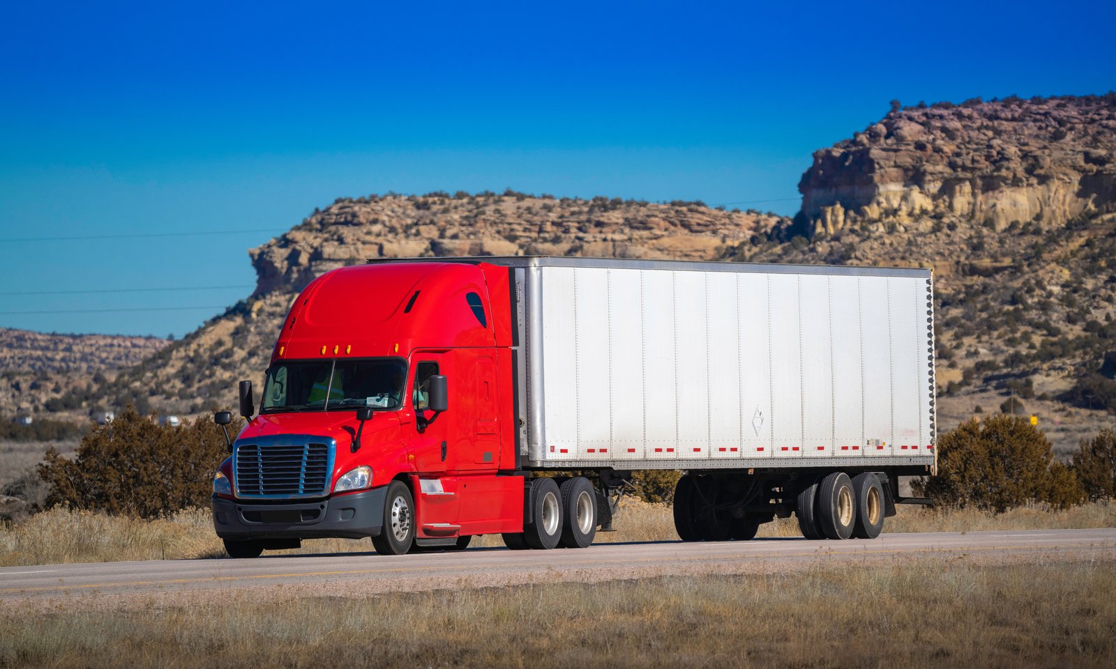 Semi-truck with cargo trailer driving on a Texas highway